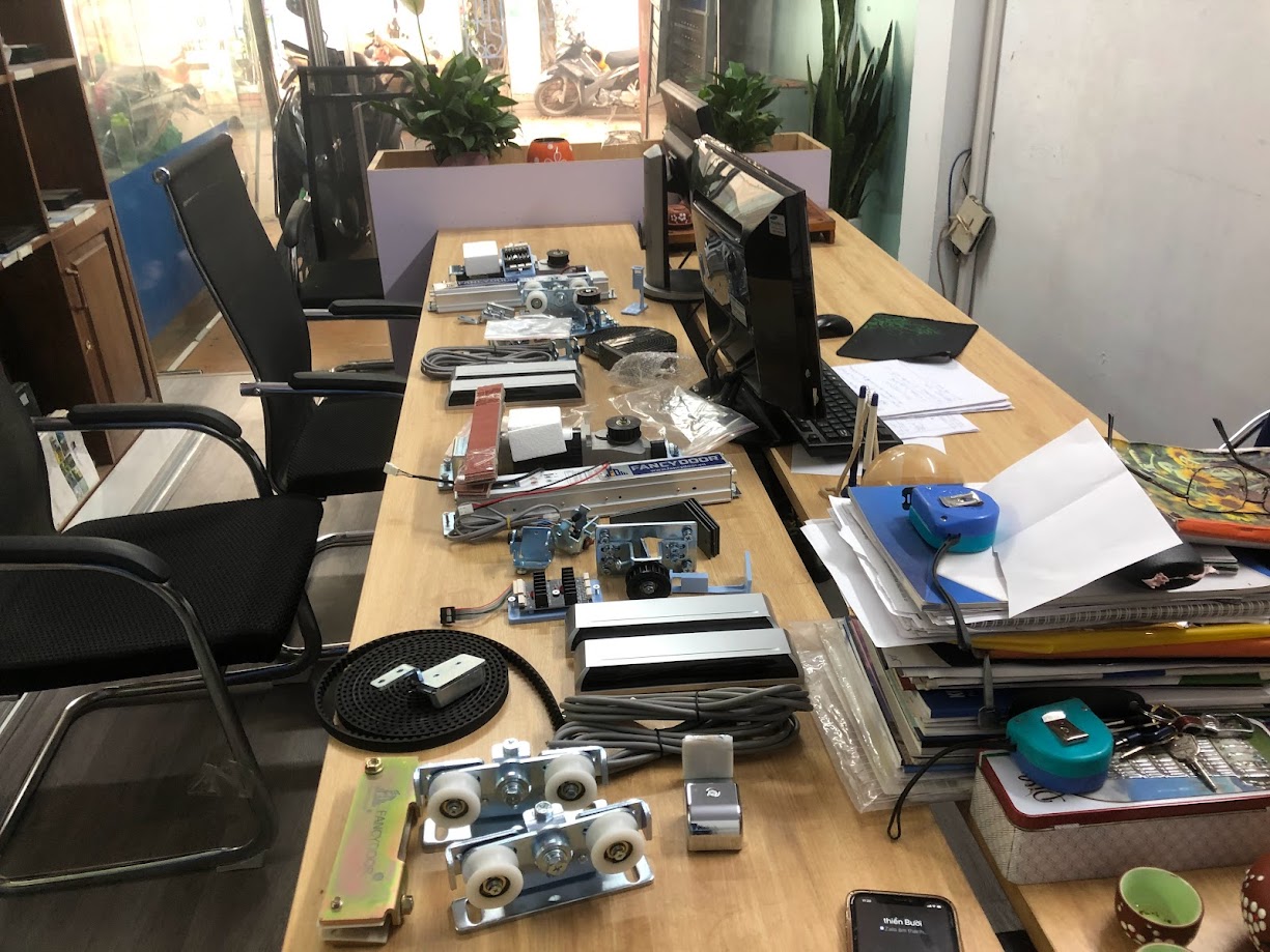Bộ phụ kiện cửa trượt tự động bày trên bàn làm việc trong văn phòng